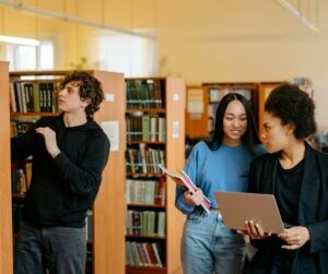 Students collaborate in a university library, engaging in research and study.